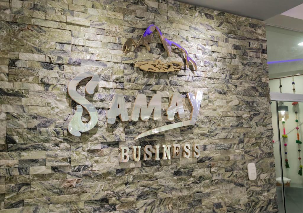 库斯科Samay Business Hotel and Departments的砖墙上贴有“烟花”商业标志