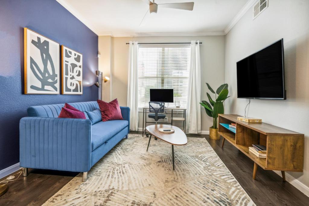 达拉斯1001 Ross Avenue的客厅配有蓝色的沙发和电视
