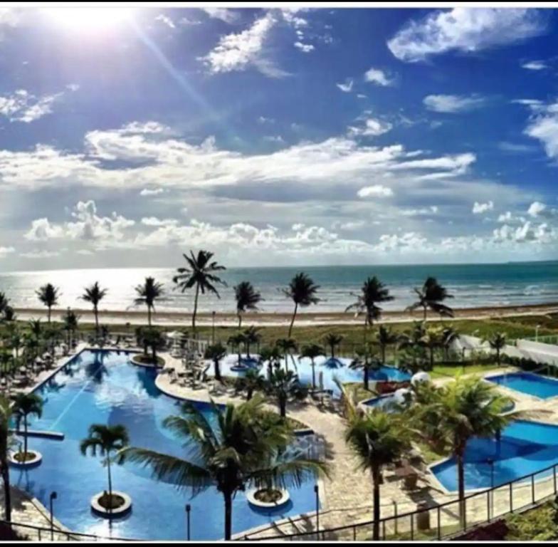 卡贝德卢Apartamento a beira-mar com piscina的享有棕榈树和海滩的度假胜地美景