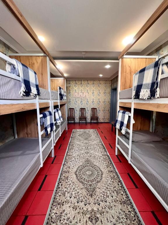 奇姆肯特InJoy hostel的客房设有四张双层床,铺有红色瓷砖地板。
