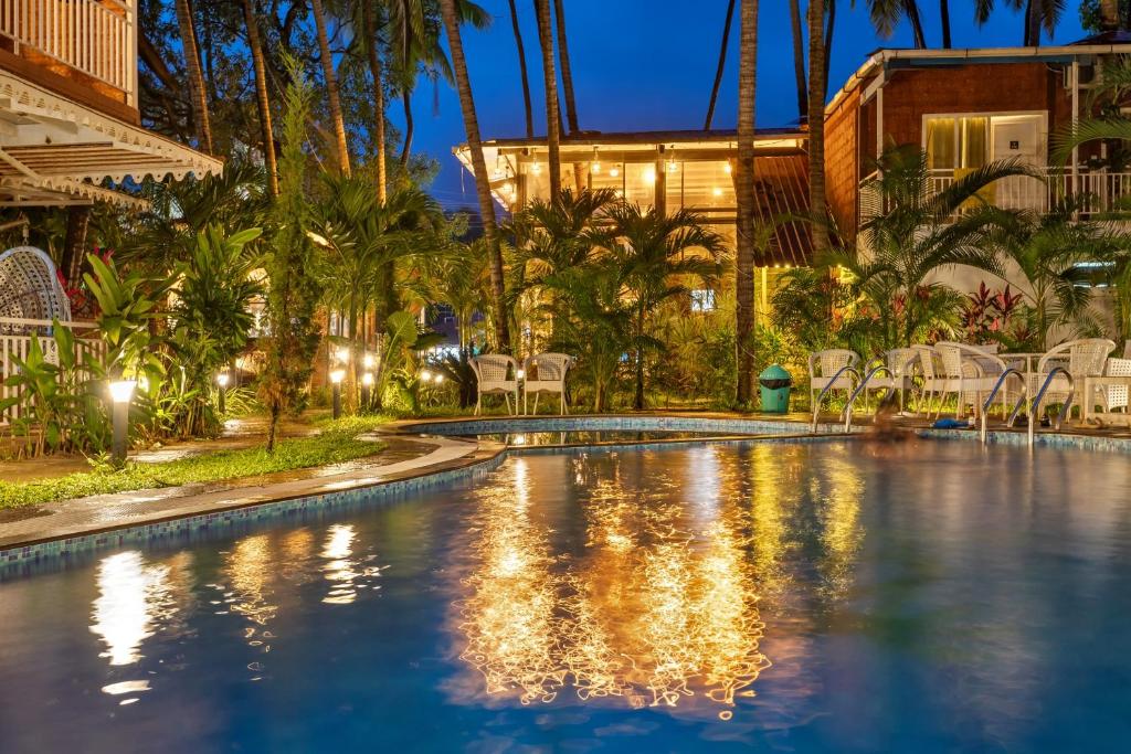 莫尔吉姆Skon Morjim Beach Resort by Orion Hotels的夜间在度假村的游泳池