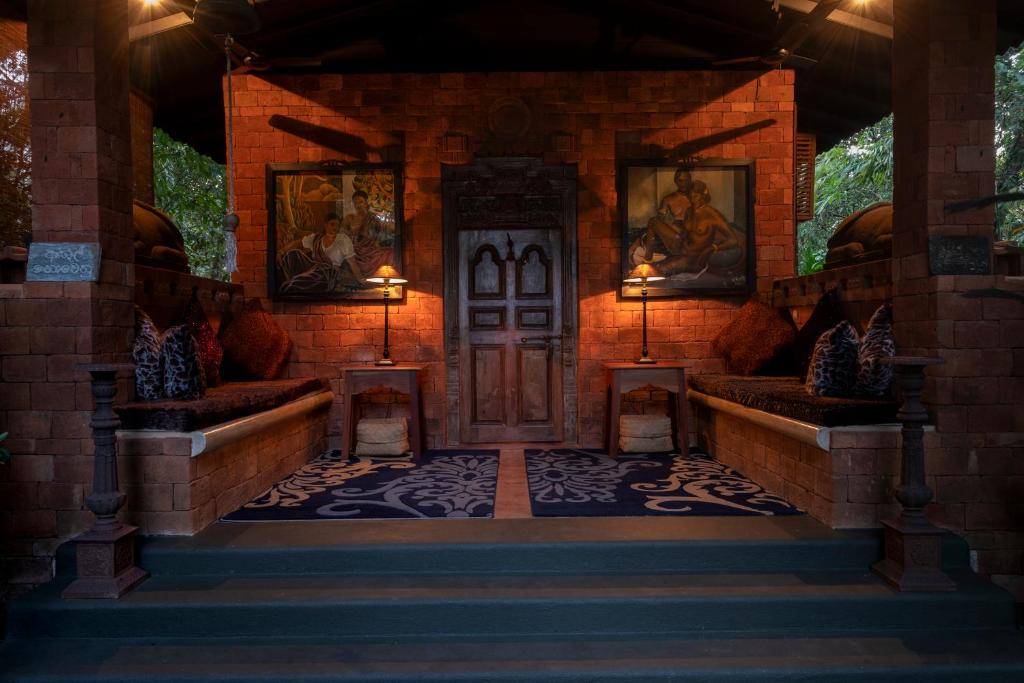 加姆珀哈Casa Heliconia的一个带木门和两个长凳的房子入口