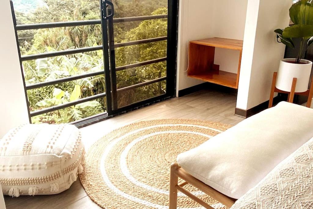 蒙泰韦尔德哥斯达黎加Calma, Monteverde - Expect Serenity Here的客房设有椅子和大窗户。
