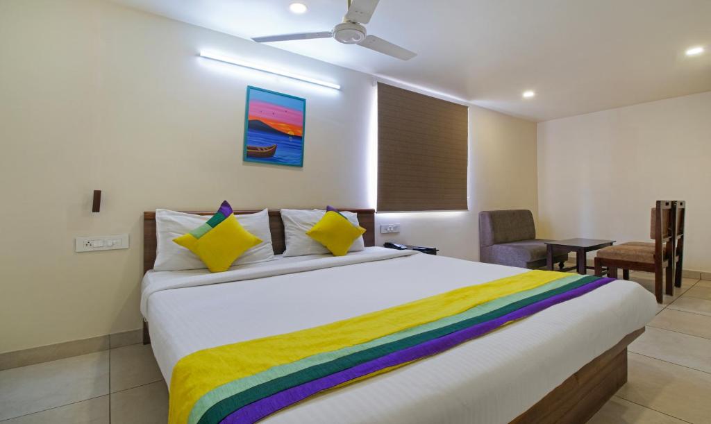 维杰亚瓦达Itsy By Treebo - N Square的一间卧室配有一张特大号床和彩色毯子