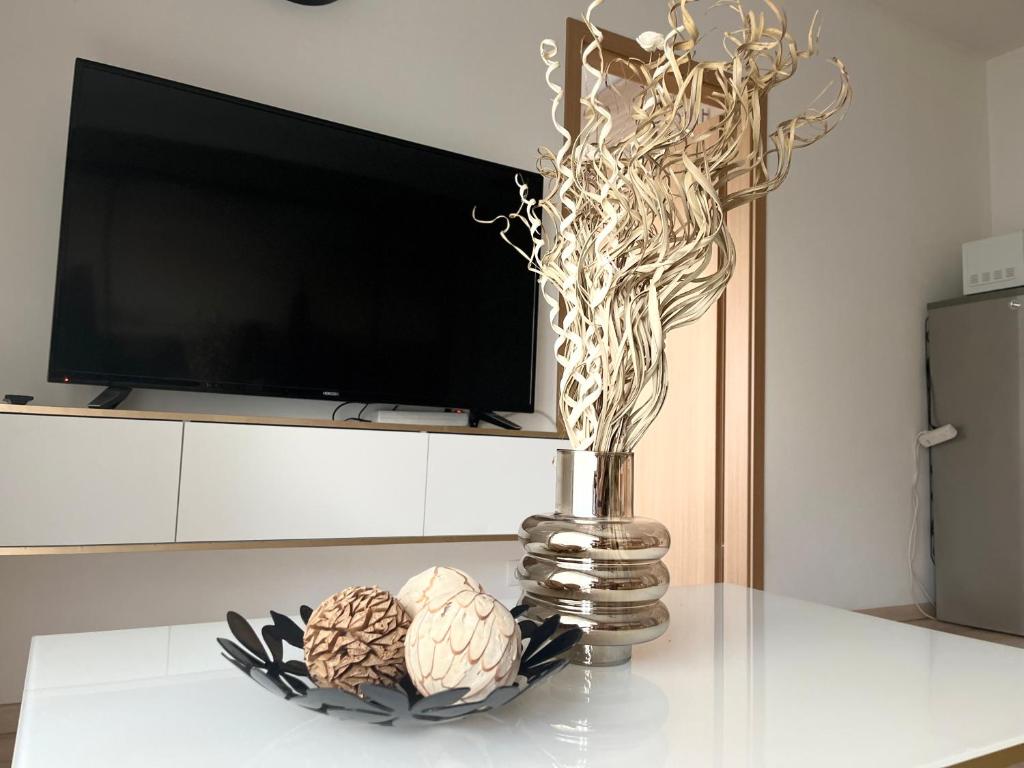 布达佩斯Corvin Promenade Crystal的一张桌子上的花瓶,带一台电视和两个球
