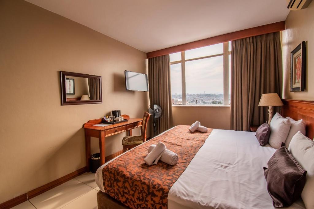 德班伊马克霍斯尼东部酒店的配有一张床、一张书桌和一扇窗户的酒店客房