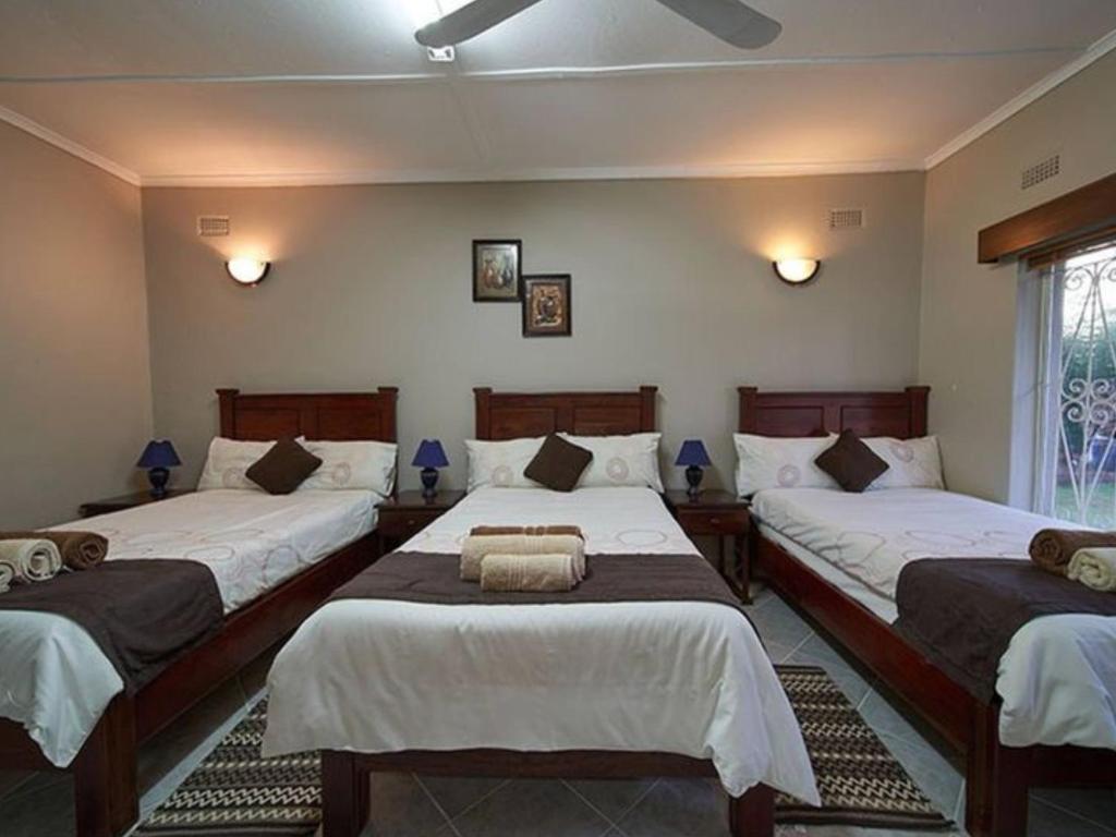 维多利亚瀑布Room in Villa - Zambezi Family Lodge - Rhino Room的一间卧室配有两张带白色床单的床