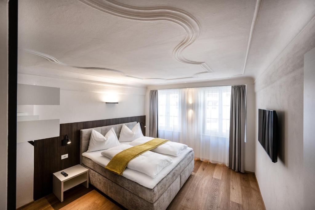布列瑟农Odilia - Historic City Apartments - center of Brixen, WLAN and Brixencard included的一间卧室设有一张床和一个大窗户