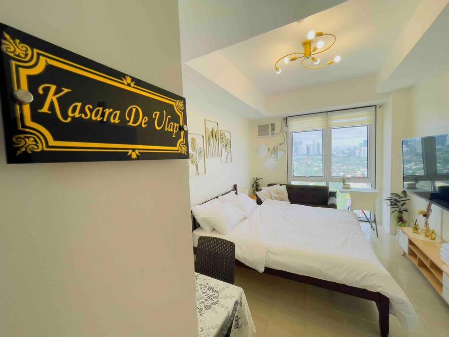 马尼拉Best Staycation - Kasara De Ulap C5 Pasig的卧室配有一张床,墙上有标志
