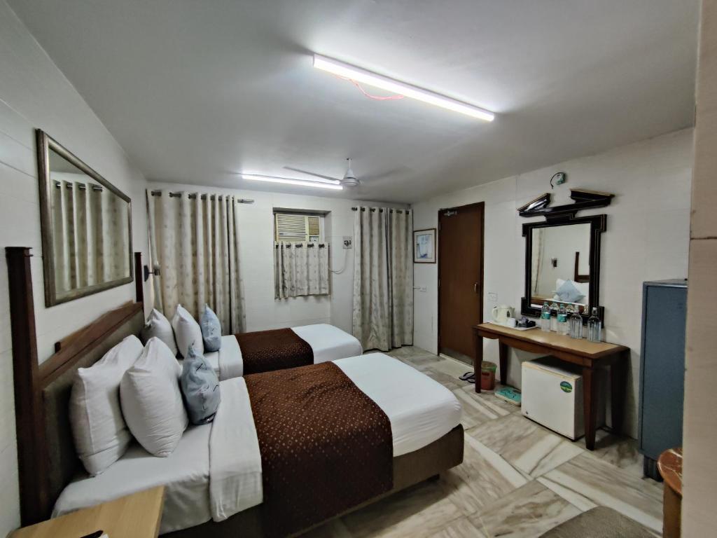 孟买Capital Hotel的酒店客房,设有两张床和镜子