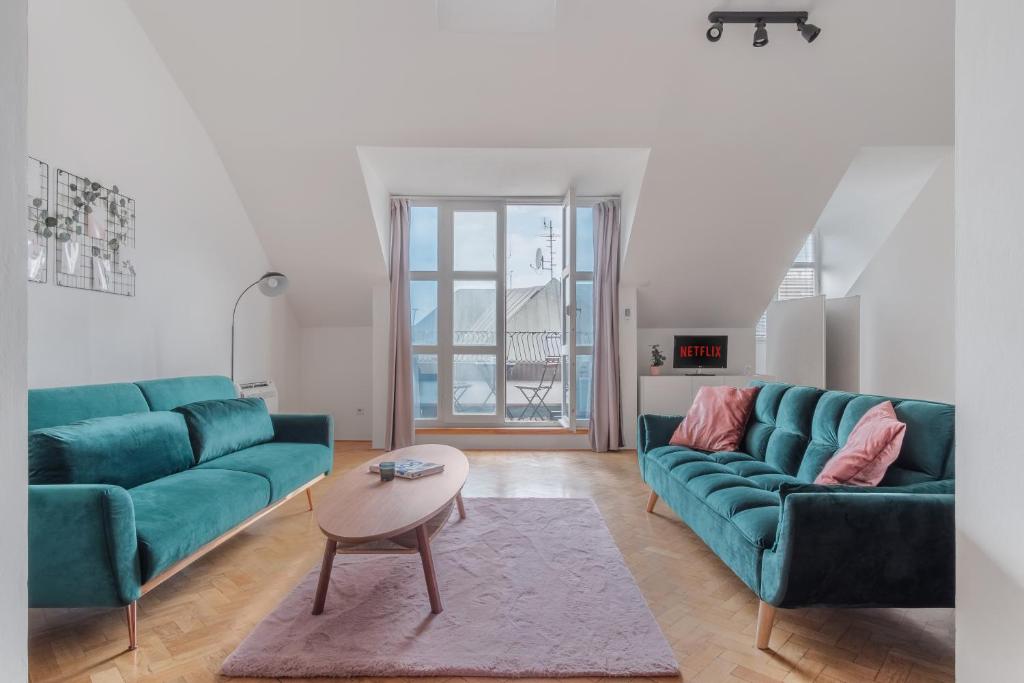 布拉格Attic Apartment in Smíchov by Prague Days的客厅配有两张绿色沙发和一张桌子