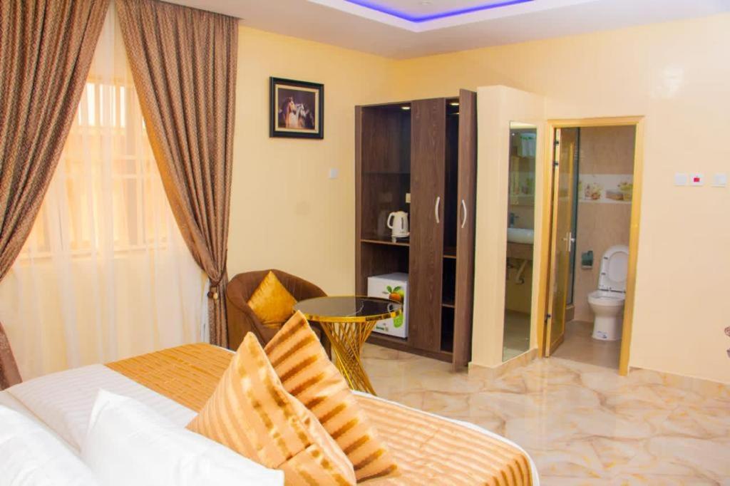 伊凯贾ERiTH APARTMENT & SUITES的一间卧室设有一张床和一间浴室。
