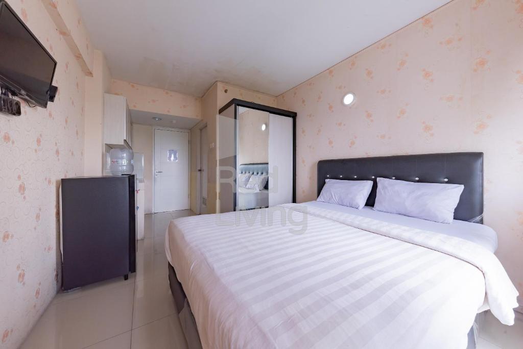 加拉旺RedLiving Apartemen Grand Sentraland - Dragon Apartel Tower Pink的一间卧室配有一张大床和电视