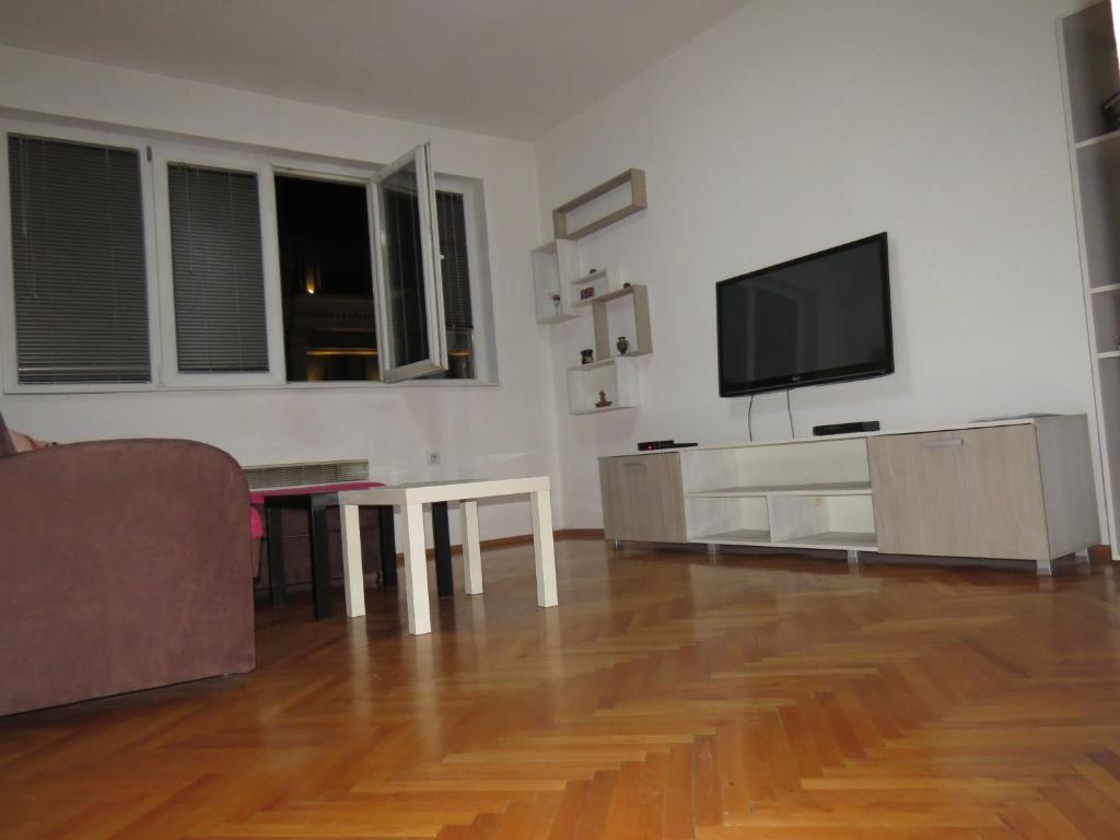 斯科普里SKOPJE REKORD APARTMENT的客厅配有电视、沙发和桌子
