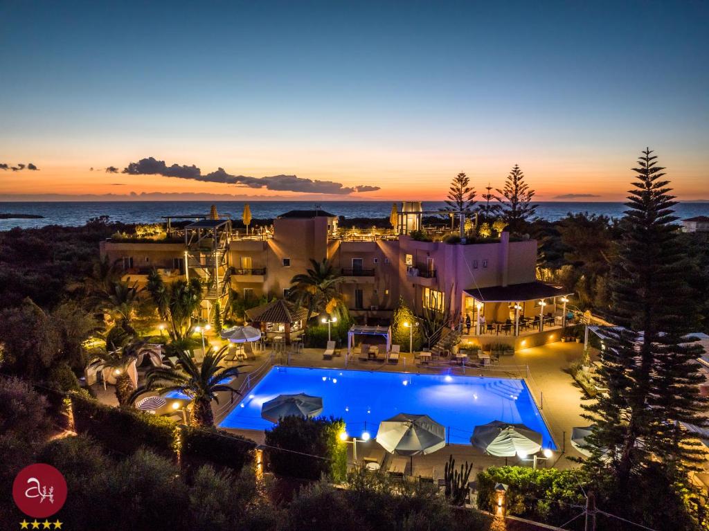 基帕里夏Apollo Resort Art Hotel的享有度假村的空中景色,晚上设有游泳池