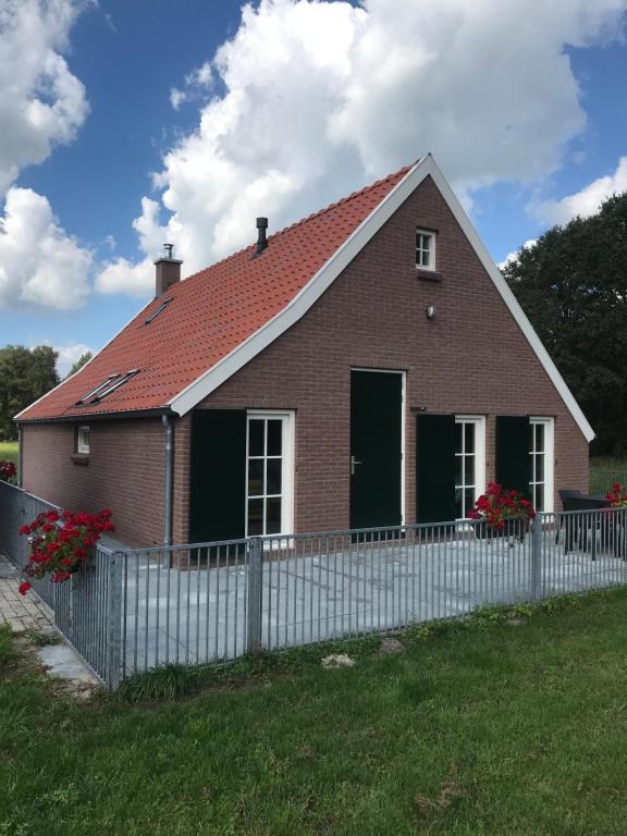 NieuwlandeDe Dagloner的白色栅栏的红砖房子