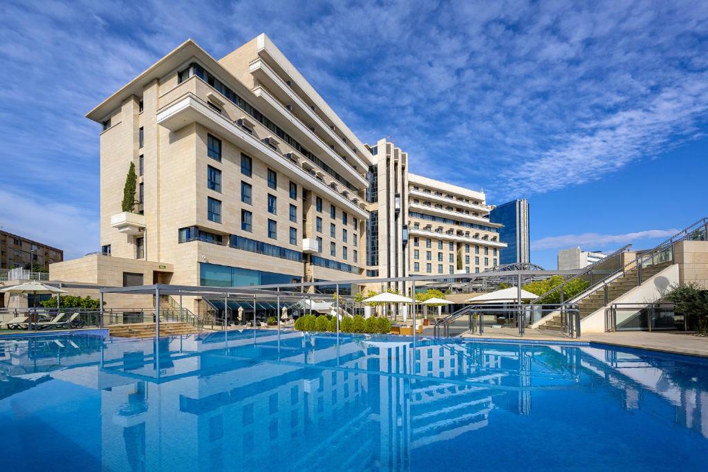 穆尔西亚内尔瓦酒店的一座大型建筑,前面设有一个游泳池