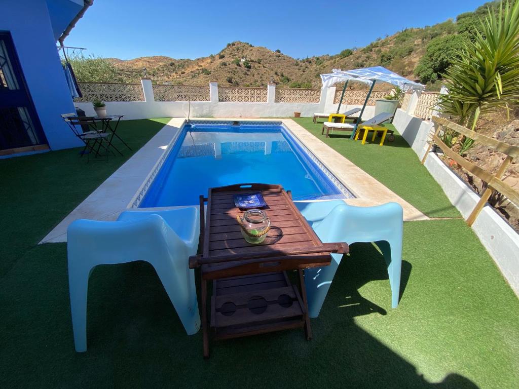 马拉加Casa Rural Los Almendros的游泳池旁的桌椅