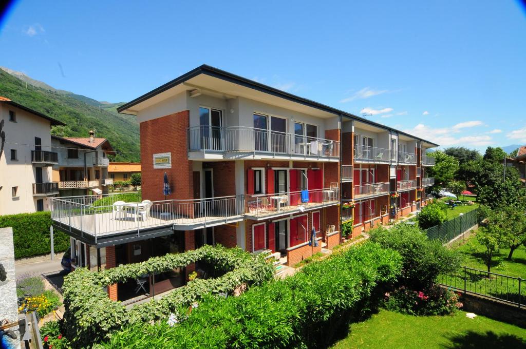 多马索风帆公寓式酒店的一座设有红色门的建筑和一个带庭院的阳台