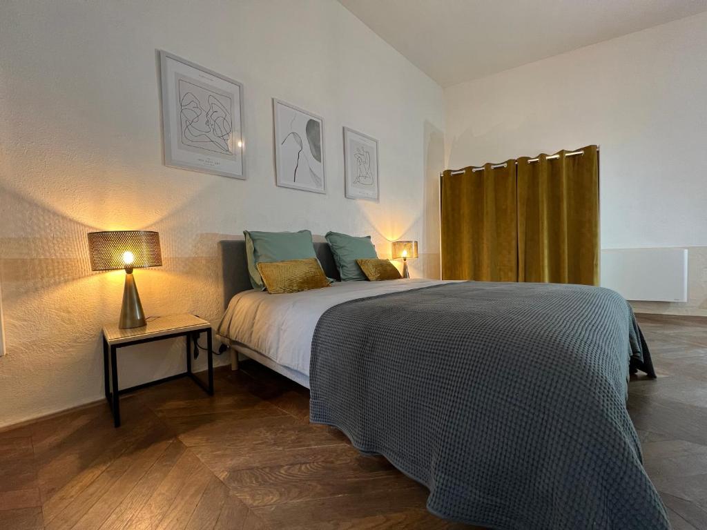 拉让提耶尔Nature & Médiéval, gîte de charme 4 étoiles的一间卧室配有一张床和一张带台灯的桌子