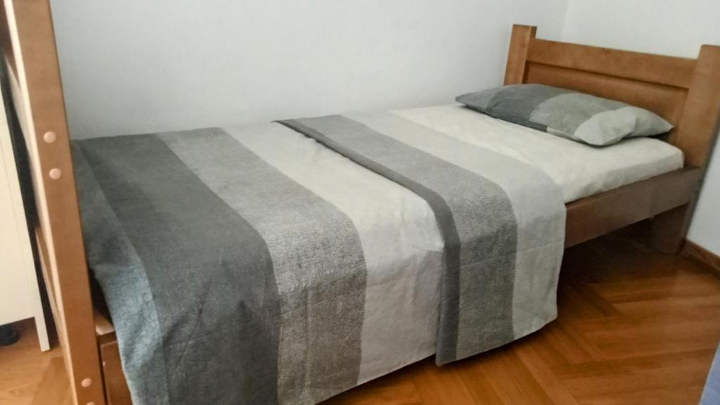 波德戈里察Central Home的床上有灰色和白色的毯子