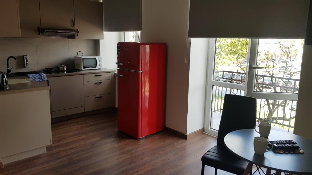 凯尔采Apartamenty Centrum Plac Wolności ApartHotel的带桌子的厨房里的红色冰箱