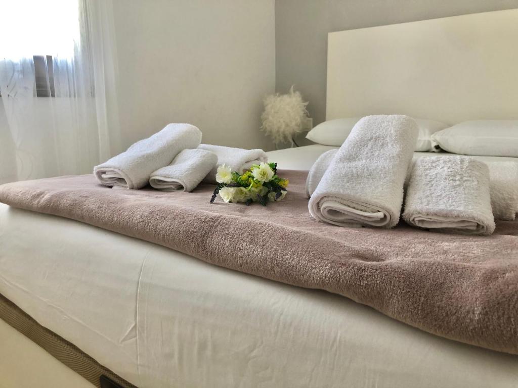 迈阿密普拉特亚La Casa de Jordi&Lina的床上有毛巾和鲜花