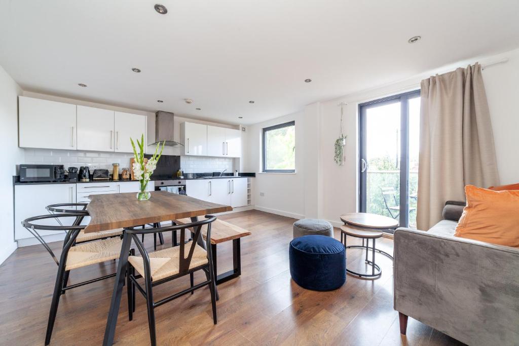 伦敦Arte Stays - 3-Bed 3-Bath Nordic Style Minimalistic Flat, Hackney Downs station 2 min walk, Great Location, Parking, Weekly or Monthly stays, Serviced Accommodation - 6 people的厨房以及带桌子和沙发的客厅。