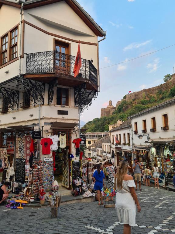 吉诺卡斯特SANTA ROOM-OLD BAZAAR CENTER-Gjirokaster的穿白色衣服的女人穿过市场