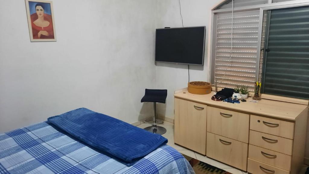 南雅拉瓜Casa do Roberto的一间卧室配有一张床、一个梳妆台和一台平面电视。