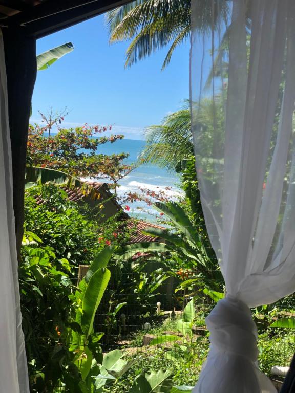 伊塔卡雷Chalé Tiririca pé na areia的客房设有可欣赏海滩景致的窗户。