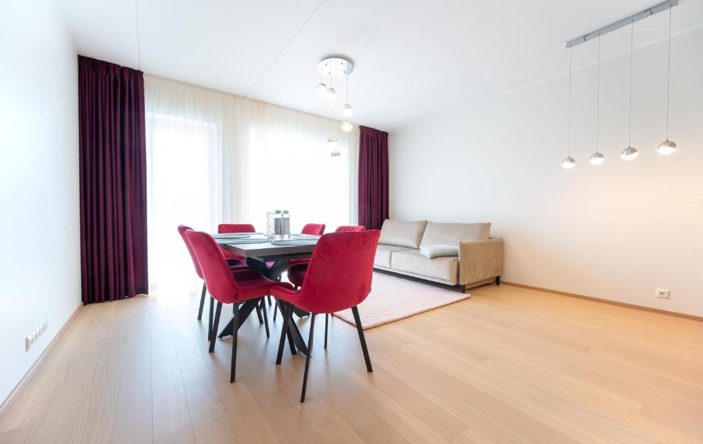塔林New apartment in Haabersti的一间带桌子和红色椅子的用餐室