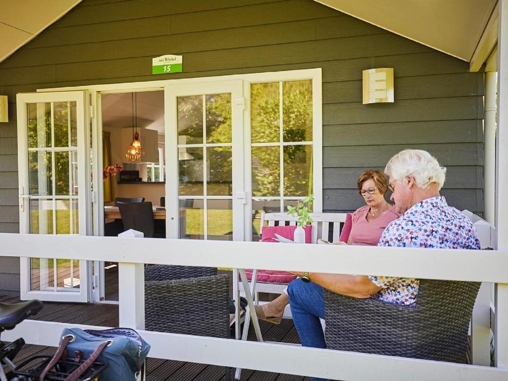 BrinkheurneCozy lodge with a dishwasher at a holiday park in the Achterhoek的两个年纪较大的妇女坐在房子的门廊上