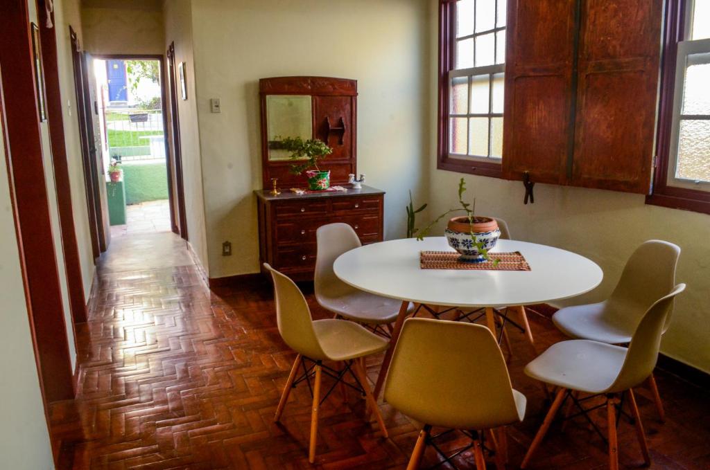 欧鲁普雷图- Casa Pitanga - Acomodação lindíssima pertinho da Igreja do Rosário的一间配备有白色桌椅的用餐室