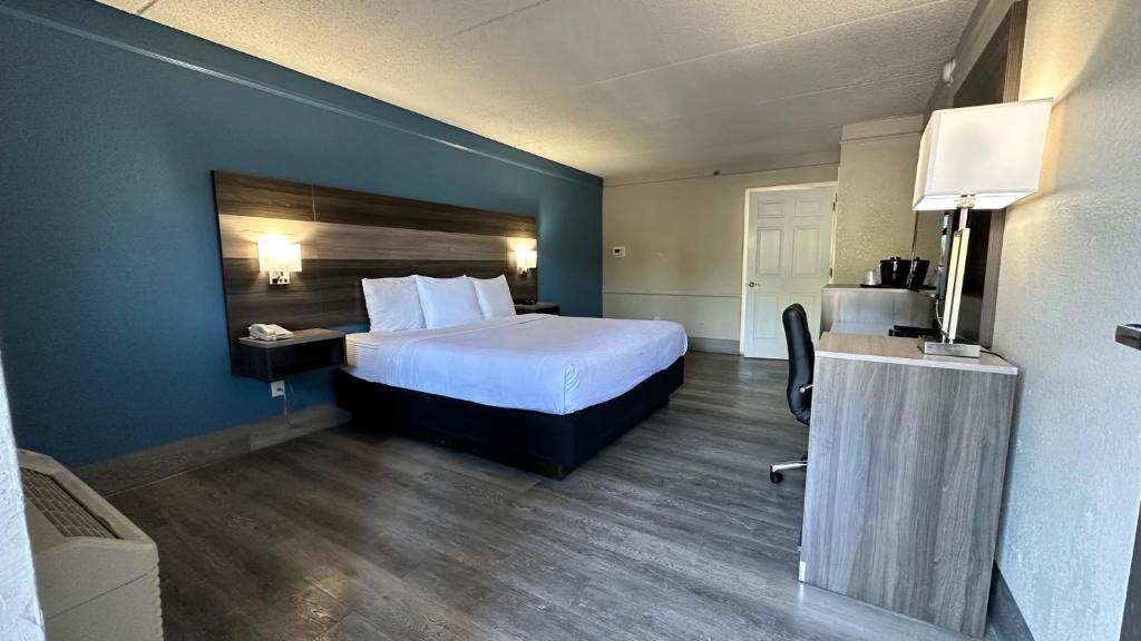 维斯塔Days Inn by Wyndham San Diego Vista的配有一张床和一张书桌的酒店客房