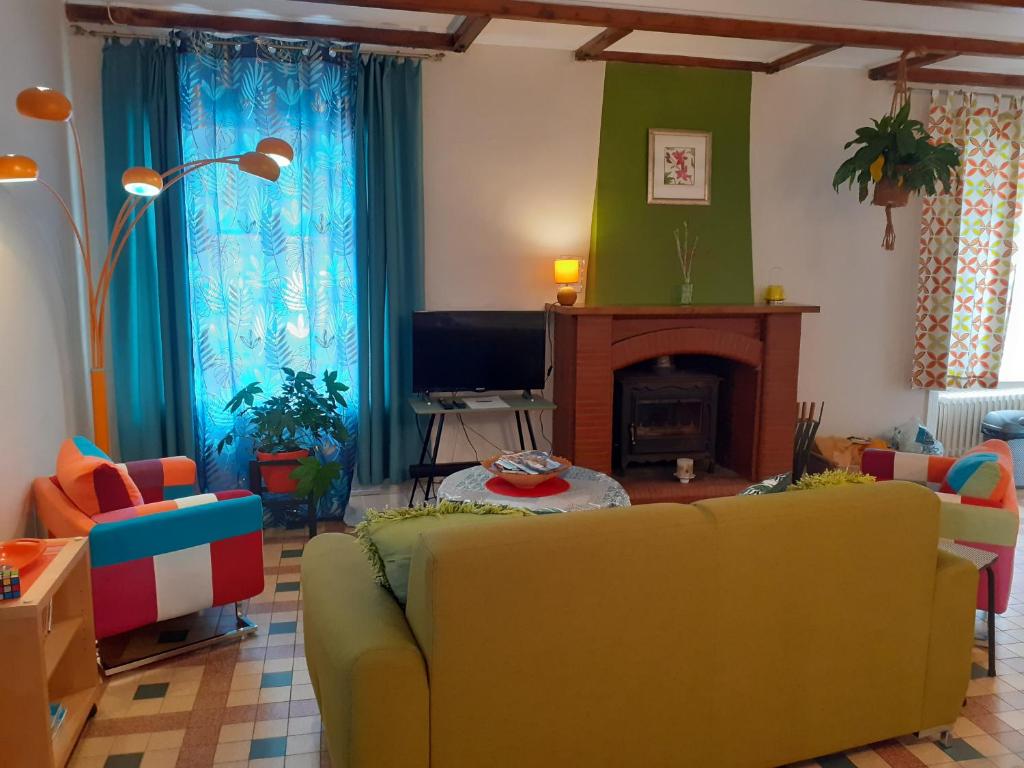 库埃斯农河畔罗Rêve du Revert的客厅设有黄色沙发和壁炉