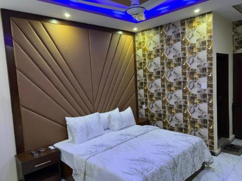 卡拉奇Defence Orchard DHA Karachi的一间卧室设有一张大床和瓷砖墙