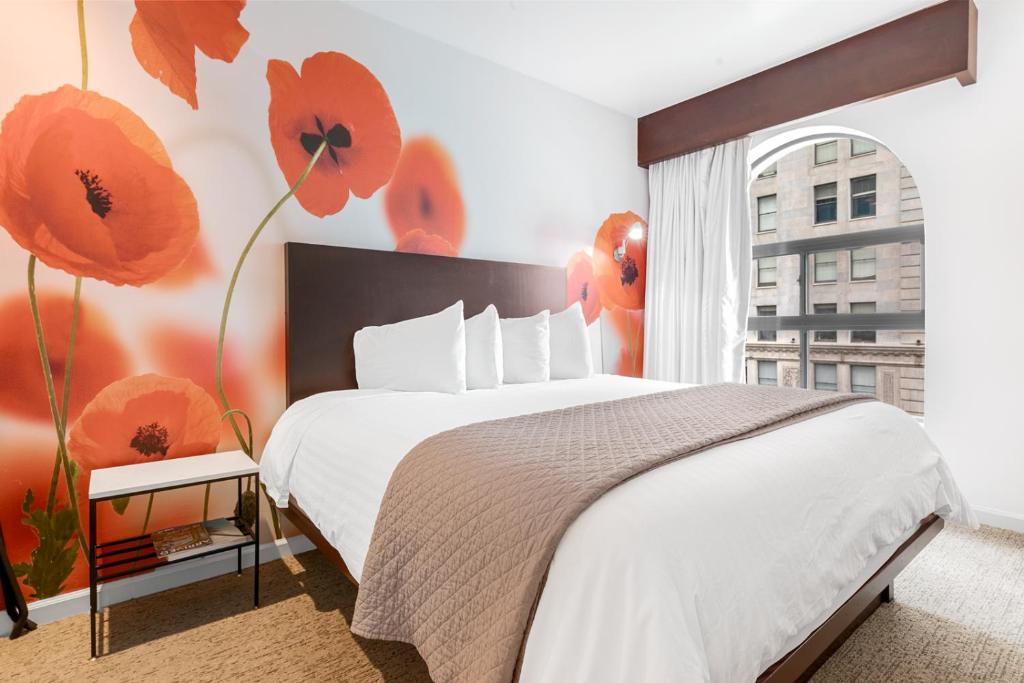洛杉矶O Hotel by LuxUrban的卧室配有一张挂着红色鲜花的床。