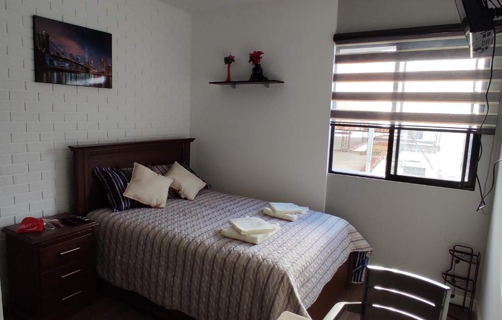 科恰班巴Monoambiente totalmente equipado y centrico的一间卧室配有一张床,上面有两条毛巾