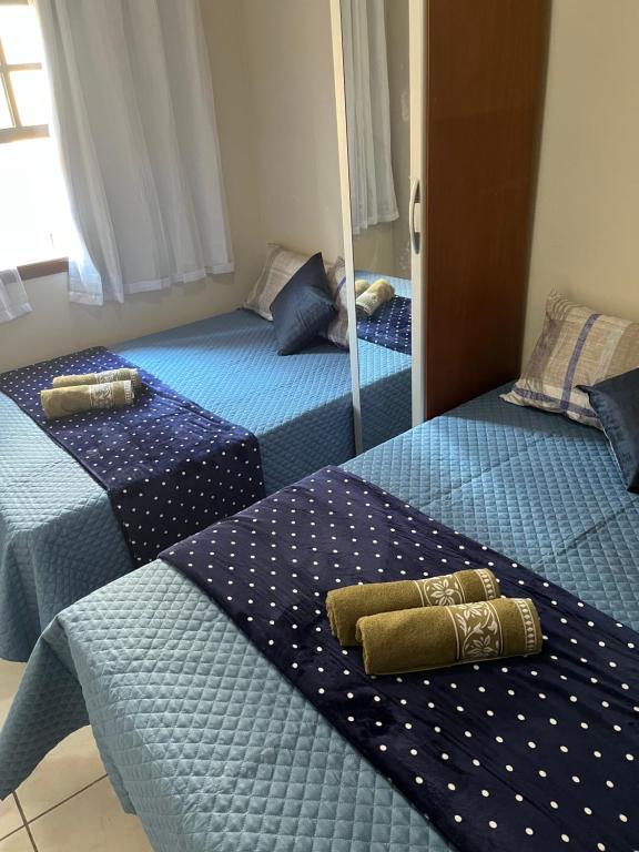 圣保罗Excelente Quarto Próximo Ao Metrô的一间卧室配有两张带蓝色床单和镜子的床