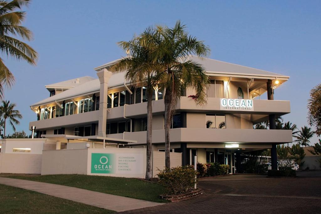 麦凯海洋国际酒店的前面有棕榈树的建筑