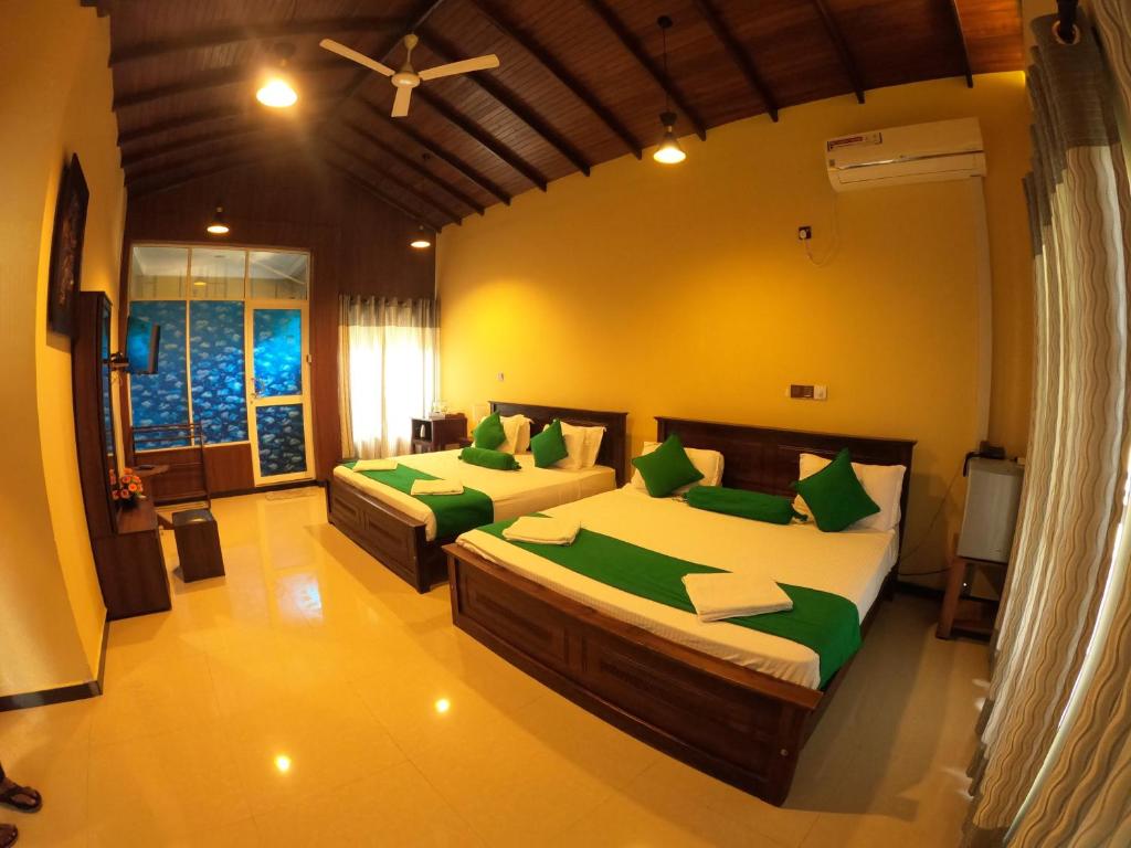 贝里胡罗亚Mount Seven Holiday Inn的一间卧室配有两张带绿色枕头的床