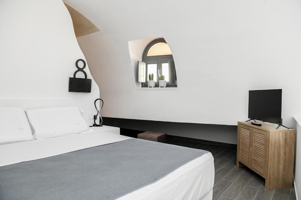莫诺利索斯Villa Eleana的一间卧室配有一张床,并在橱柜上配有电视