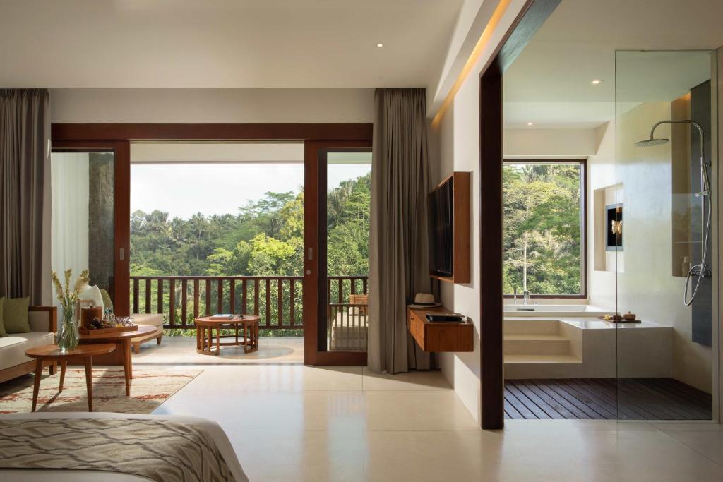 德格拉朗Cicada Luxury Resort - Ubud的一间卧室设有带浴缸的浴室和阳台