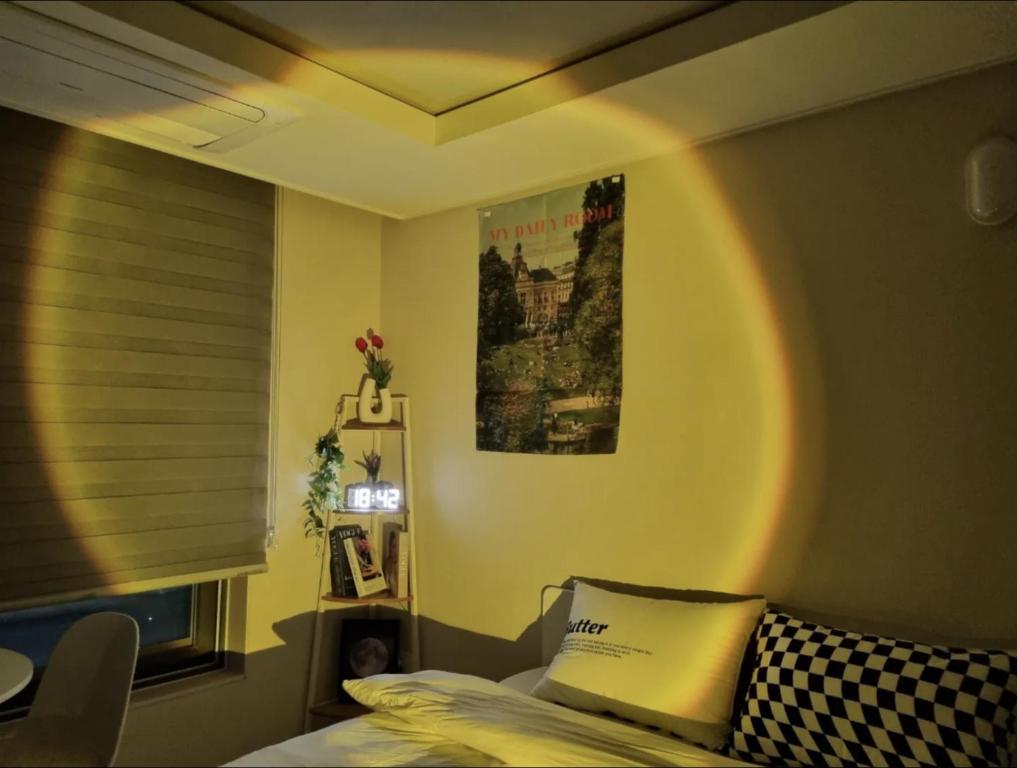 大邱DAON STAR BnB j6的卧室配有一张床,墙上挂着一幅画