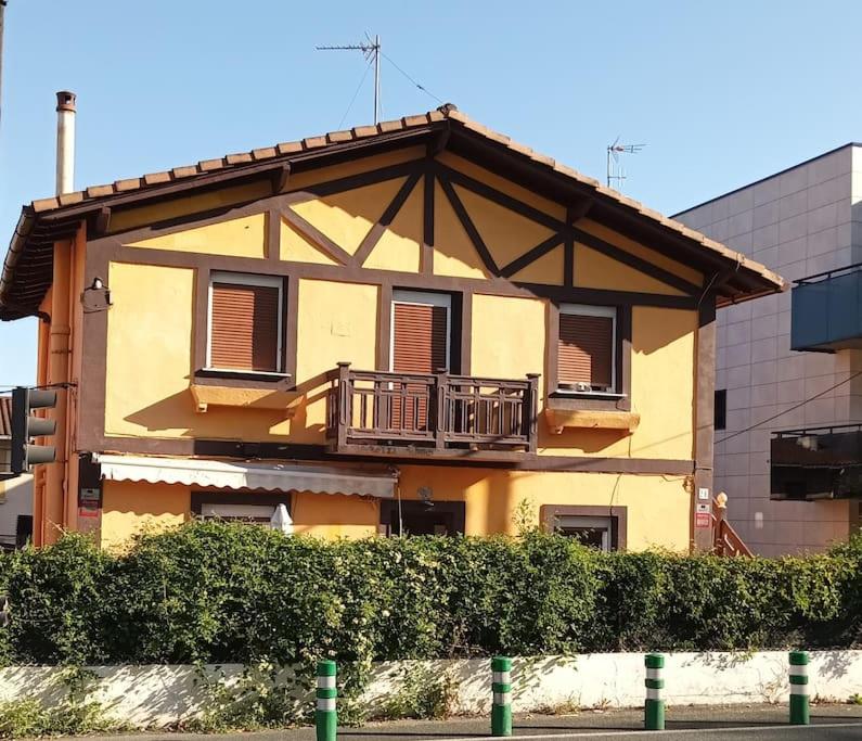 伊伦Preciosa casa bi-familiar al lado de Donosti.的黄色的建筑,上面设有阳台