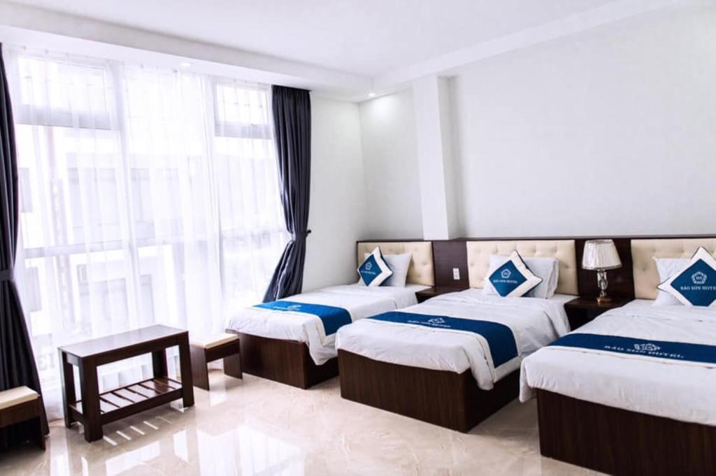 下龙湾Bảo Sơn Hotel的酒店客房设有两张床和窗户。