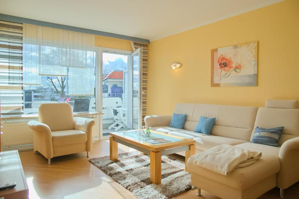 格洛米茨Haus Ostseeblick App 8 inkl WLAN的客厅配有沙发、椅子和桌子