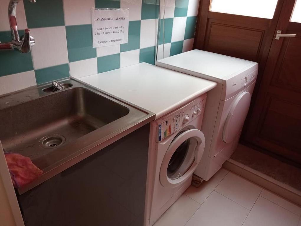 卢阿尔卡Albergue de Peregrinos Villa de Luarca的厨房配有洗衣机和水槽