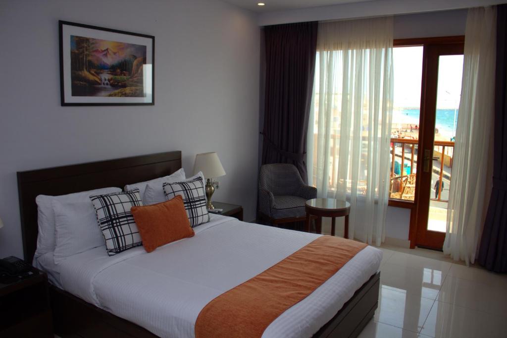 卡拉奇Destination Beach Hotel by Dreamworld的酒店客房设有一张床和一个阳台。